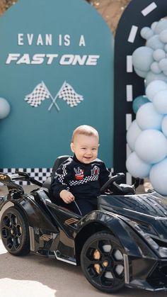 a baby sitting on top of a black toy car in front of a sign that says, evans a fast one