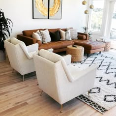 a living room with couches, chairs and rugs