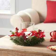 a coffee table topped with red and white poinsettis next to a cup