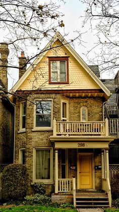 an old brick house with yellow front door and stairs leading up to the second story