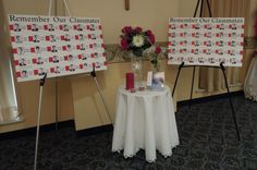 a table with flowers and pictures on it in front of a sign that says remember our classimes