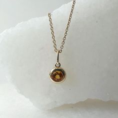 Materials: 14k Gold Gemstone: Genuine Citrine Total Citrine Carat Weight: 0.16 ct. Pendant Diameter: 11mm x 5.4mm (including bale) Citrine Size: 3.5mm x 3.5mm Necklace: Adjustable 16 and 18 inches with a lobster clasp. Chain Weight: 0.6mm 1.35 grams Description: Option for pendant only, necklace available as an add on. The necklace is 16 and 18 inches adjustable, with a lobster clasp at the end. Please check measurements prior to purchasing, as this is a dainty pendant. A beautiful round citrine Yellow Gold Birthstone Necklace With Round Stone, Yellow Gold Birthstone Gemstones, Round Shape, Yellow Gold Birthstone Gemstone, Gold Round Gemstones With Polished Finish, Round Gold Gemstones With Polished Finish, Yellow Gold Topaz Jewelry With Bezel Setting, Yellow Gold Birthstone Gemstone Pendant, Gold Gemstones With Bezel Setting In Fine Jewelry, Gold Gemstones Birthstone