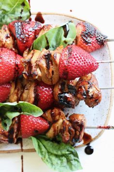 strawberries and chicken skewers on a plate