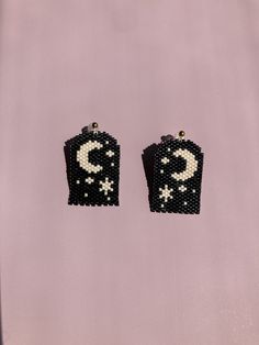 pair of black and white beaded earrings on pink background