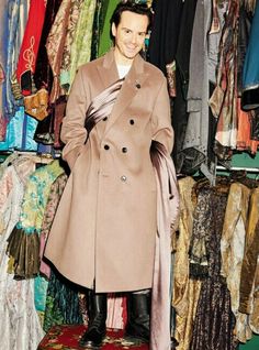 a man standing in front of a rack of clothes