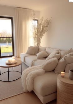 a living room filled with furniture next to a large open window covered in white curtains