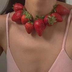 a woman wearing a pink top with strawberries on her neck