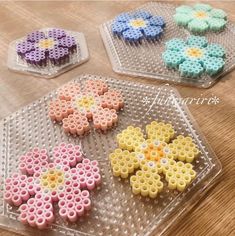 three plastic trays with flower shaped beads on them