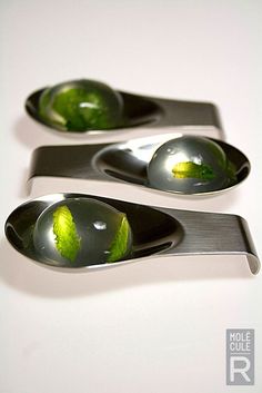 three metal spoons with green leaves on them