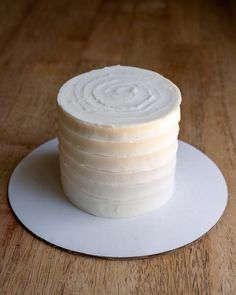 a stack of white cake sitting on top of a wooden table next to a knife