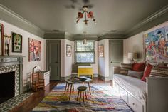 a living room filled with furniture and a fire place in front of a painting on the wall