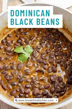 a pot filled with beans and topped with cilantro next to a wooden table