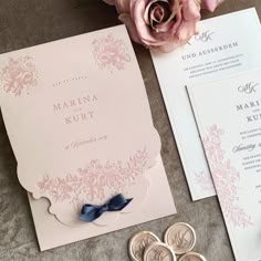 the wedding stationery is laid out on top of the table with flowers and buttons