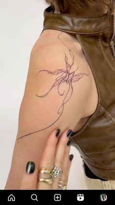 a woman's arm with a tattoo on it and a leather vest over her shoulder