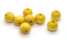 several yellow lemons are shown on a white surface, with holes in the middle