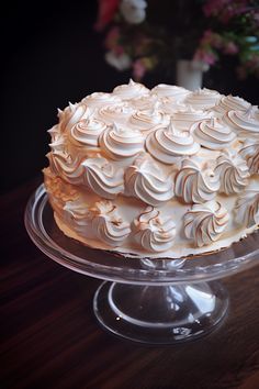 a frosted cake sitting on top of a glass plate