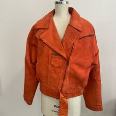 Asymmetrical Women’s 1980’s Orange Leather Jacket. Bomber/Motorcycle Style. In Great Condition Only Some Light Discoloration In Small Areas. Across Shoulders- 20in. Sleeve Length- 22.5in. Front Length- 19in. Back Length- 22in. Waist- 44in Vintage Long Sleeve Biker Jacket For Fall, Retro Fall Biker Jacket For Workwear, Retro Fall Biker Jacket For Work, Retro Biker Jacket For Workwear In Fall, Retro Single-breasted Leather Jacket With Long Sleeves, Orange Free People Jacket, Orange Leather Jacket, Orange Single-breasted Long Sleeve Outerwear, Orange Button-up Outerwear With Pockets