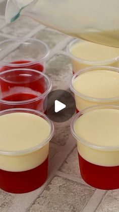 several plastic cups filled with liquid sitting on top of a tile floor