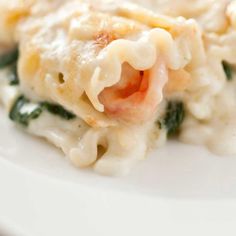 a plate with pasta and spinach covered in sauce on it's side, ready to be eaten