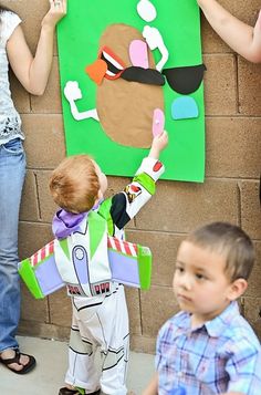 a group of children standing in front of a brick wall with paper cutouts on it