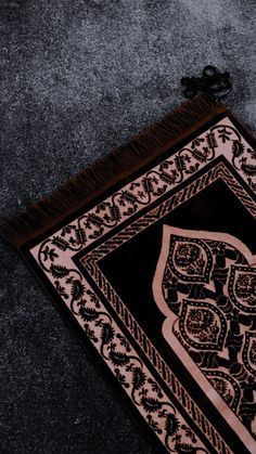 an intricately designed rug on the ground with a black and brown border around it