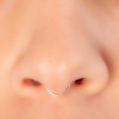 a close up view of a nose with a curved nose ring