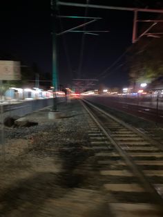 an empty train track at night with the lights on