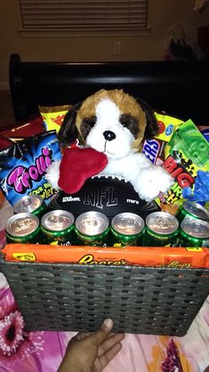 a dog is sitting in a basket filled with beer and snacks, along with candy