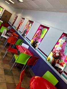 brightly colored chairs line the walls of a fast food restaurant with posters on the wall