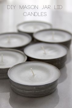 six white candles sitting on top of a table with the words diy mason jar lid candles