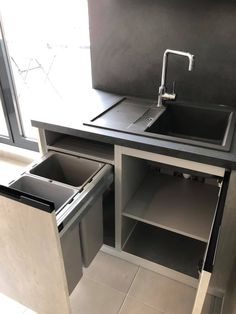 a kitchen sink and cabinets in a room with tile flooring on the walls, along with a window