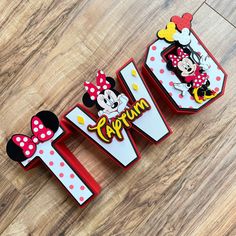 three pieces of paper with minnie and mickey mouse on them sitting on a wooden floor