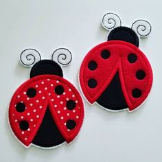 two red and black ladybugs with white polka dots on them, sitting side by side