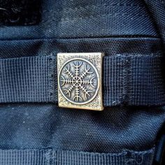 a close up view of a metal buckle on a blue jeans pocket with an intricate design