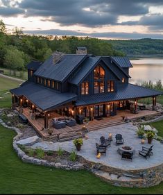 an aerial view of a house with patio and fire pit in the foreground at dusk