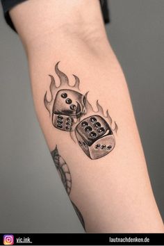 a tattoo with dices on it and flames coming out of the back of his arm