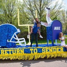 two people on a float that says return to sender with football helmets and letters