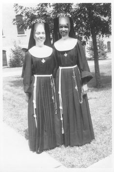 two women in black dresses standing next to each other