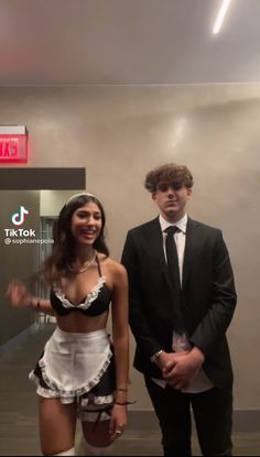 a man and woman standing next to each other in front of a sign that says tiktok