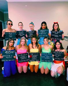 a group of women dressed in costumes holding signs