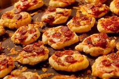 mini pizzas are arranged on a baking sheet and ready to be baked in the oven