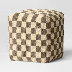 a brown and white checkerboard pattern poufce sitting on top of a floor