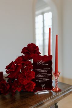 red flowers and candles sit on a table