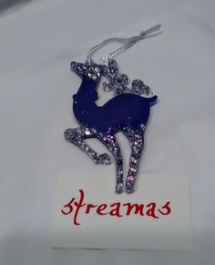 an ornament with a deer on it and the name streamas written in red