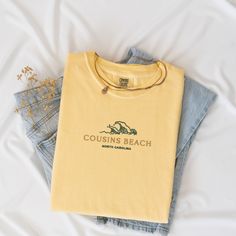 Welcome to Cousins Beach, North Carolina! Our comfortable and stylish tee captures the essence of the beach with its scenic wave design embroidered on the center chest. Made from 100% cotton Comfort Colors garment dye, this tee is available in sizes S-2XL and comes in vibrant colors including Banana, Butter, Chambray, Ivory, Peachy, and White. Please note that colors may vary slightly due to monitor settings. Check out our size charts in the images section to find your perfect fit! Beach Embroidered Short Sleeve T-shirt, Embroidered Short Sleeve Beach T-shirt, Embroidered Short Sleeve T-shirt For Beach, Embroidered Cotton T-shirt For Beach, Cousins Beach, Banana Butter, Beach North Carolina, Summer Apparel, Beach Wave