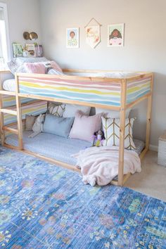 a bedroom with a bunk bed, rug and pictures hanging on the wall above it