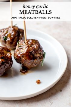 three meatballs with toothpicks on a white plate