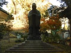 there is a statue in the middle of some steps and trees behind it with leaves on them