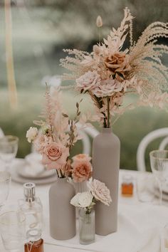 two vases with flowers are sitting on a table