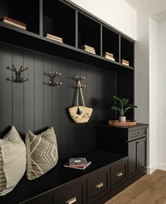 a room with black walls and wooden flooring is decorated with decorative wall hangings